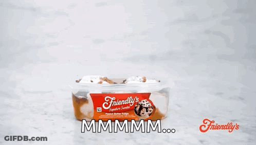 A Person Is Holding A Spoon Over A Container Of Friendly 'S Peanut Butter Fudge . GIF