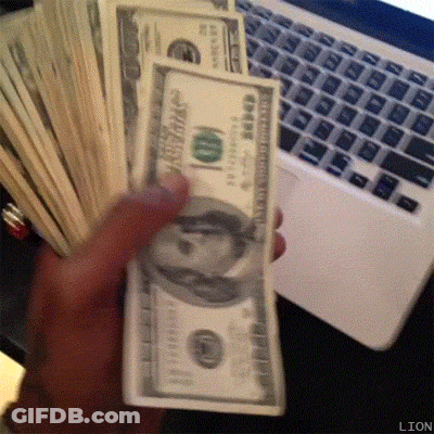 A Person Is Holding A Stack Of 100 Dollar Bills In Front Of A Laptop Keyboard GIF