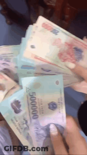 A Person Is Holding A Stack Of Money That Says 500000 On It GIF