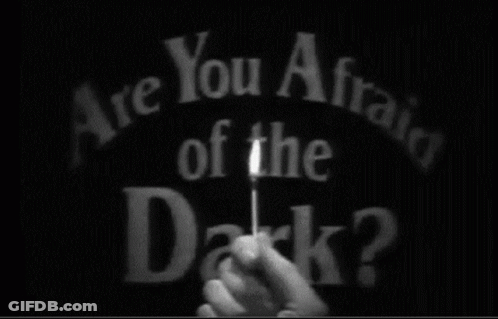 A Person Is Holding A Stick In Front Of The Words Are You Afraid Of The Dark ? GIF