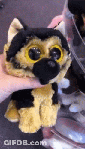 A Person Is Holding A Stuffed Animal That Looks Like A German Shepard GIF