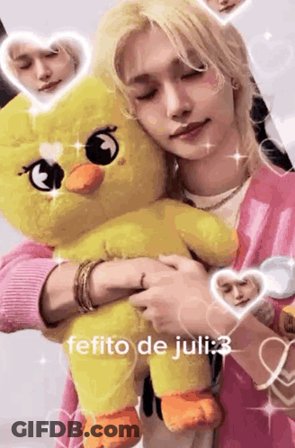 A Person Is Holding A Stuffed Duck In Their Arms . GIF