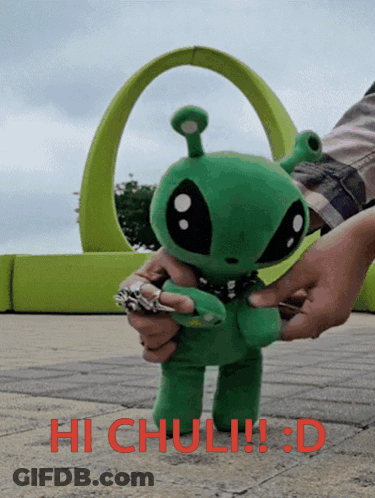 A Person Is Holding A Stuffed Green Alien With The Words Hi Chuli !!! D Written On The Bottom GIF