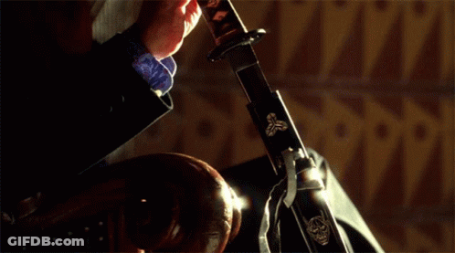 A Person Is Holding A Sword In Their Hand GIF