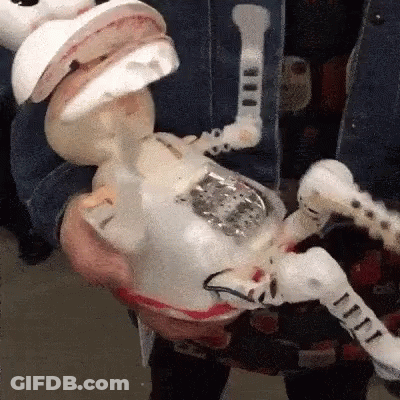 A Person Is Holding A Toy That Looks Like A Skeleton With A Mouth Open GIF