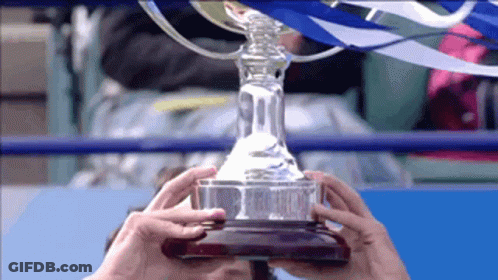 A Person Is Holding A Trophy In Their Hands That Says ' R ' On It GIF