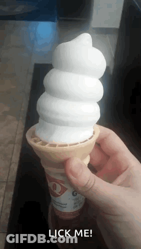 A Person Is Holding A Vanilla Ice Cream Cone That Says Lick Me GIF