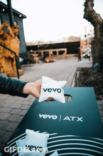 A Person Is Holding A Vevo Pillow Over A Vevo Atx Board GIF