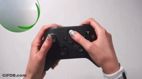 A Person Is Holding A Video Game Controller In Their Hands GIF