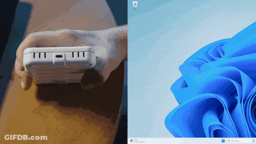 A Person Is Holding A White Device Next To A Blue Flower GIF