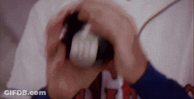 A Person Is Holding A White Object In Their Mouth With The Letter H On Their Shirt GIF