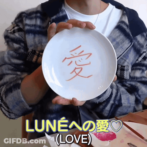 A Person Is Holding A White Plate With Chinese Characters On It GIF