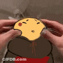 A Person Is Holding A Yellow Cartoon Character In Their Hands And Petting It . GIF