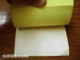 A Person Is Holding A Yellow Sticky Note And A Piece Of Paper GIF