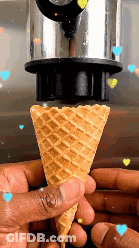 A Person Is Holding An Ice Cream Cone With Hearts Flying Around It GIF