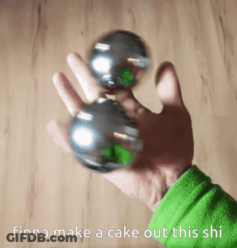 A Person Is Holding Two Metal Balls In Their Hand With The Words Finna Make A Cake Out This Shi Below Them GIF