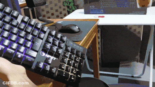 A Person Is Holding Up A Keyboard That Says Nft On It GIF