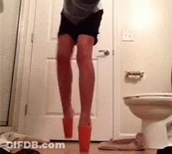 A Person Is Jumping In A Bathroom Next To A Toilet GIF