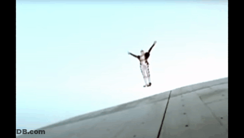 A Person Is Jumping In The Air With Their Arms Outstretched .. GIF