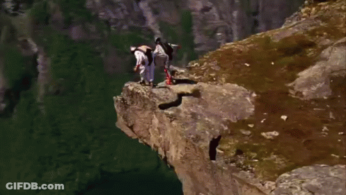 A Person Is Jumping Off A Cliff Into A Body Of Water GIF