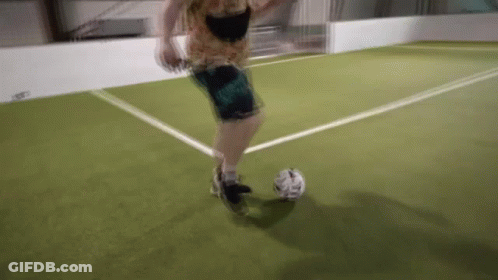 A Person Is Kicking A Soccer Ball On A Field GIF