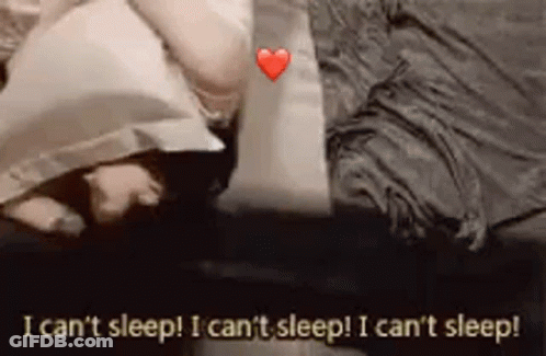 A Person Is Laying On A Bed With A Pillow And A Heart . GIF