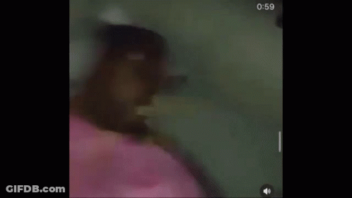 A Person Is Laying On A Bed With A Pink Blanket And Headphones . GIF