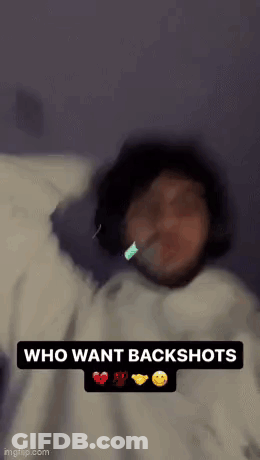 A Person Is Laying On A Bed With A Toothbrush In Their Mouth And The Words `` Who Want Backshots '' . GIF