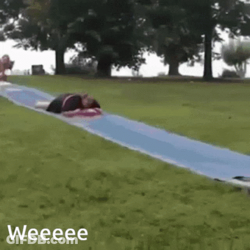 A Person Is Laying On A Blue Slide With The Words Weeeee Below It GIF