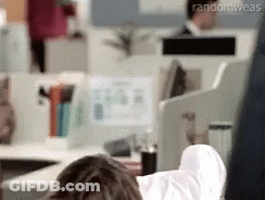 A Person Is Laying On A Desk With Their Feet Up In An Office . GIF