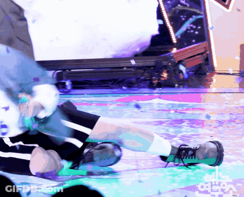 A Person Is Laying On A Stage With A Sign That Says ' Mbc ' On It GIF