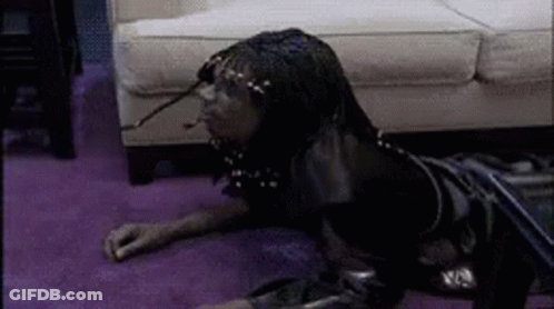 A Person Is Laying On The Floor In Front Of A Couch . GIF