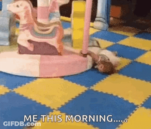 A Person Is Laying On The Floor In Front Of A Merry Go Round And Says Me This Morning . GIF