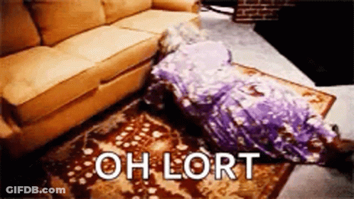 A Person Is Laying On The Floor Next To A Couch With The Words `` Oh Lort '' Written On The Rug . GIF