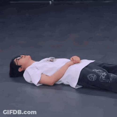 A Person Is Laying On The Floor With Their Hands On Their Hips GIF
