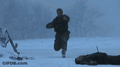 A Person Is Laying On The Ground Holding A Gun GIF