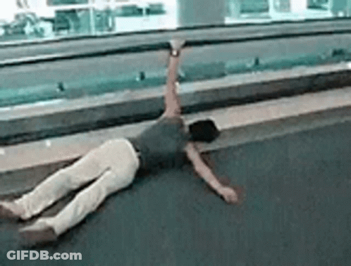 A Person Is Laying On Their Back On The Floor With Their Arms Outstretched . GIF