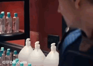 A Person Is Looking At Bottles Of Hand Sanitizer In A Store . GIF