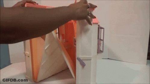 A Person Is Opening A Doll House With A Key GIF