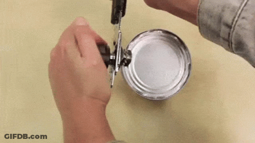 A Person Is Opening A Tin Can With A Can Opener . GIF