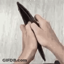 A Person Is Opening An Empty Wallet With Their Hands . GIF