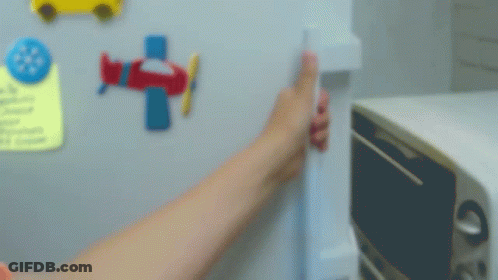 A Person Is Opening The Door Of A Refrigerator With A Yellow Item In It GIF