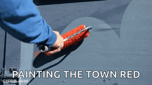 A Person Is Painting The Town Red With A Red Paint Roller GIF