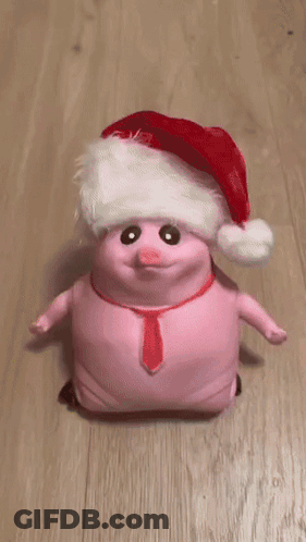 A Person Is Petting A Pink Pig Wearing A Santa Hat And Tie GIF