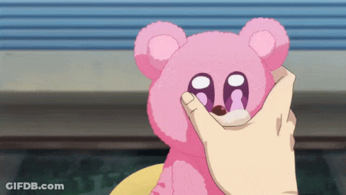 A Person Is Petting A Pink Teddy Bear With The Letter Aa On Its Eyes GIF