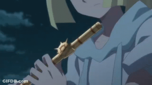 A Person Is Playing A Flute In A Dark Room GIF