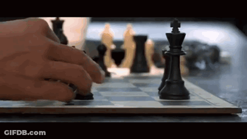 A Person Is Playing A Game Of Chess And Moving A Piece On The Board . GIF