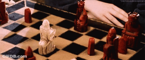A Person Is Playing A Game Of Chess With Red And White Chess Pieces . GIF