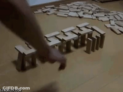 A Person Is Playing A Game Of Dominoes On A Wooden Floor GIF