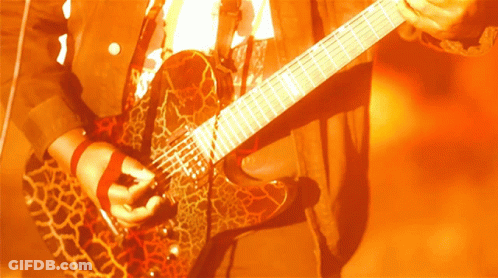A Person Is Playing A Guitar With A Leopard Print GIF